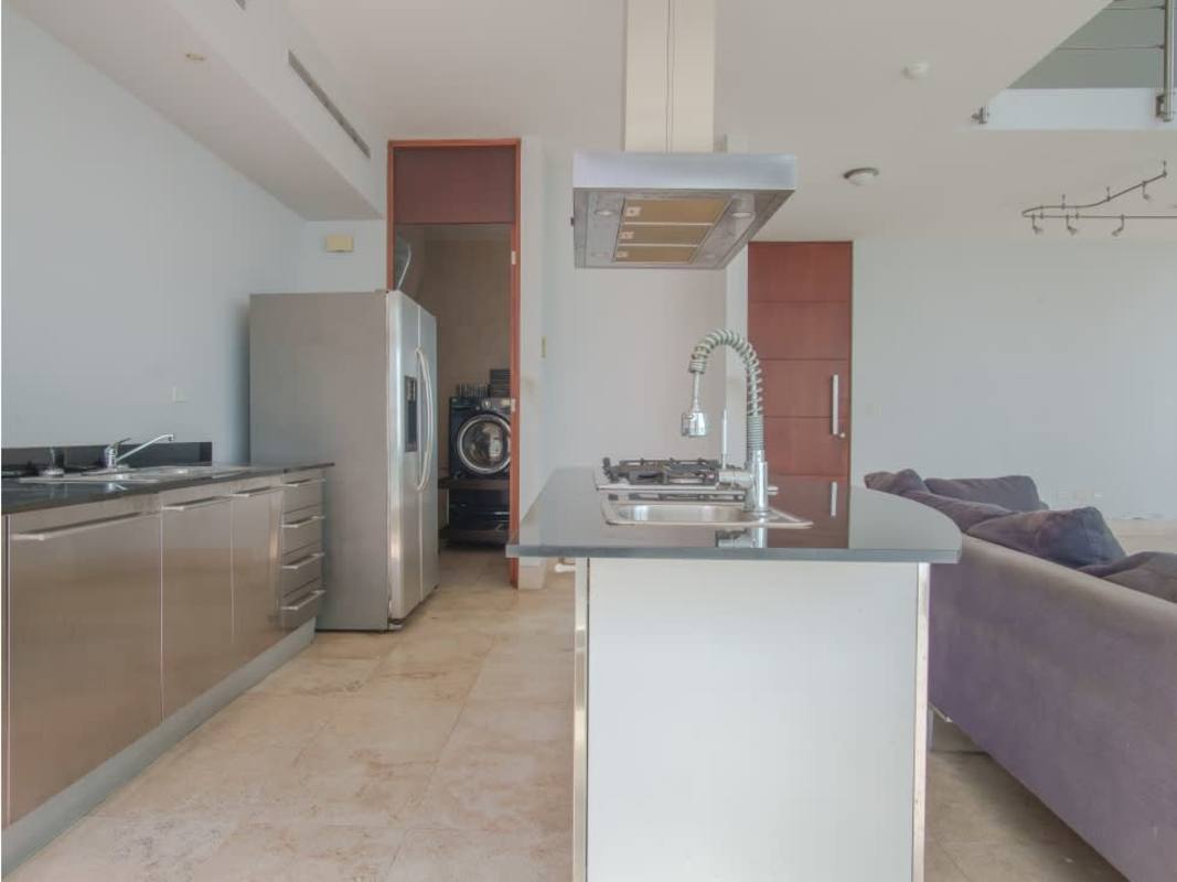 Open concept kitchen with island granite countertop and dining area in Loft Four 41 Panama