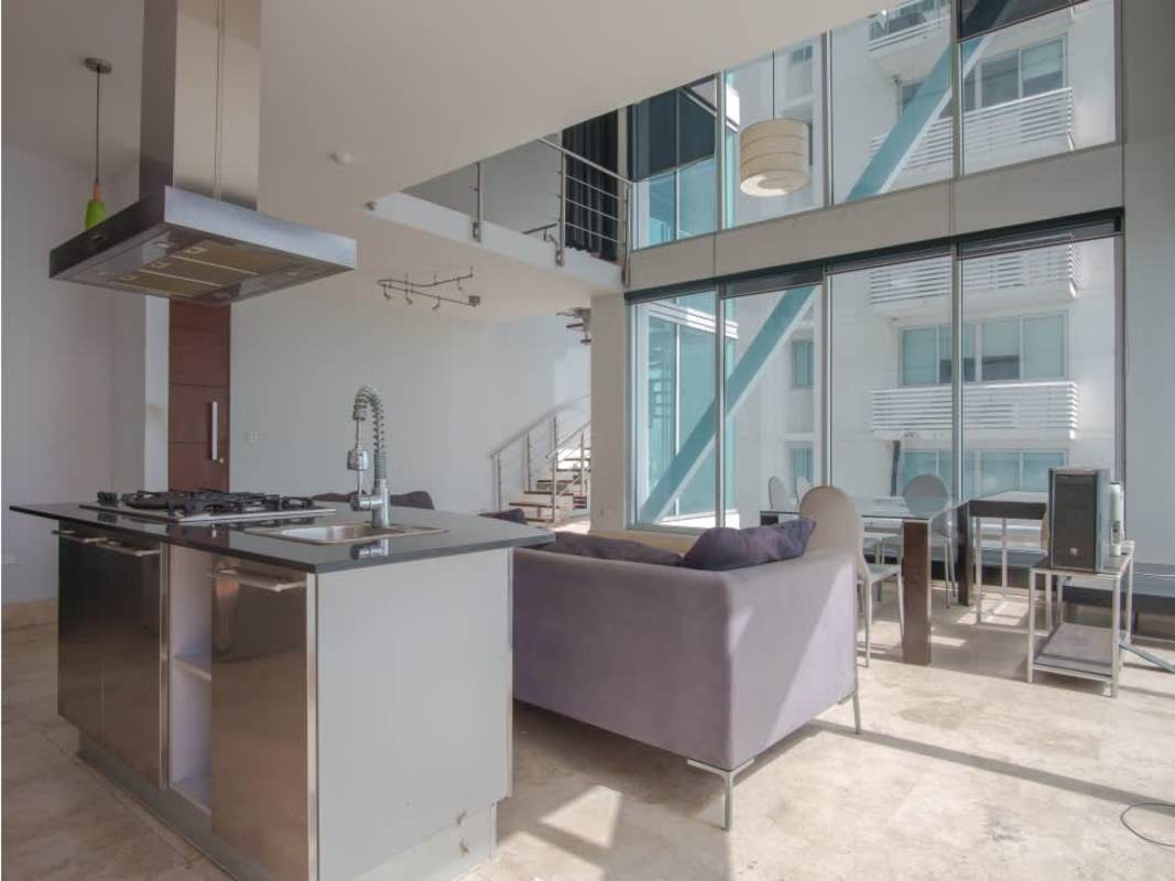 Spacious double height living room with spiral staircase and panoramic windows in Loft Four 41 Panama