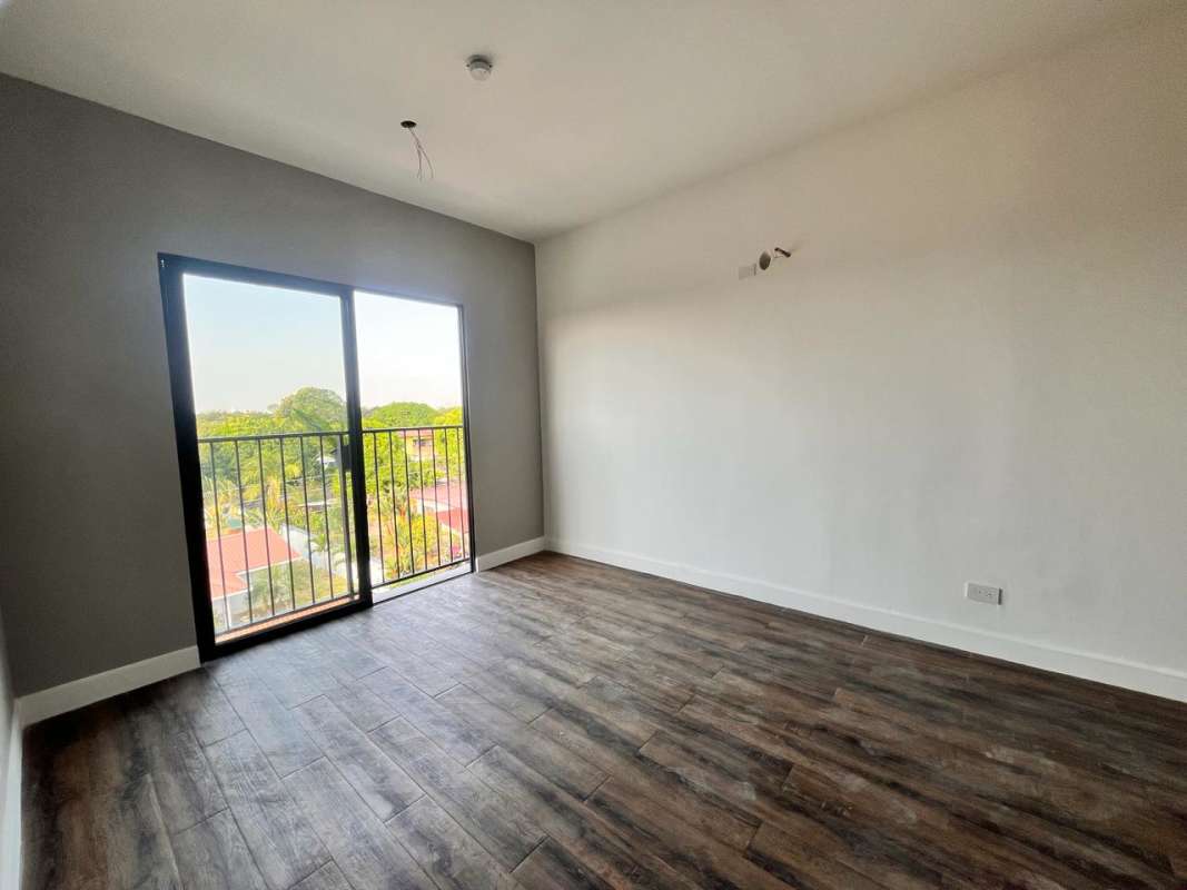 Bright bedroom with wood floors and balcony in new Las Acacias apartment