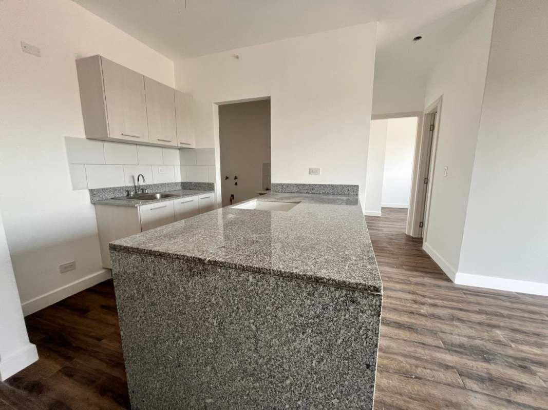 Minimalist empty bedroom with window and wood floors in Las Acacias apartment