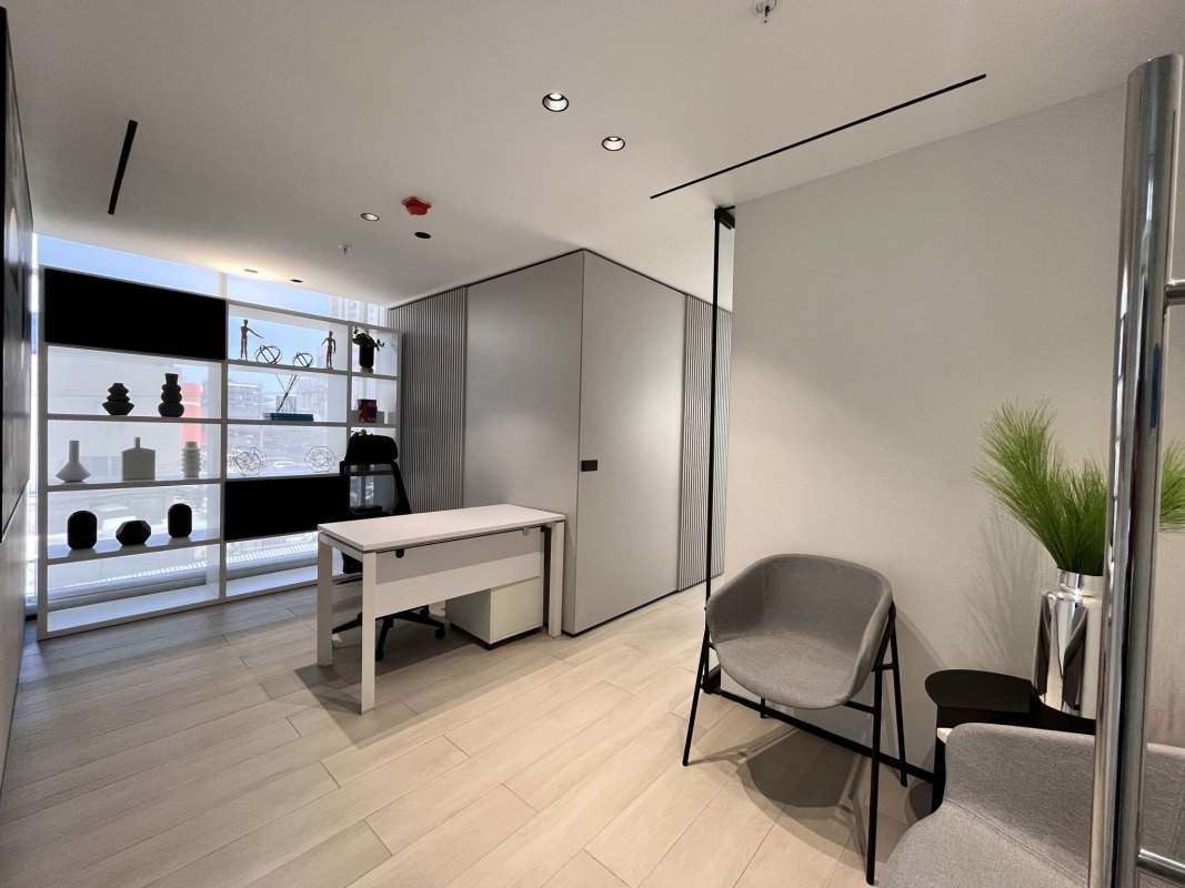 Modern office hallway with elevators, recessed lights, and emergency signage Park Square Medical Center Panama