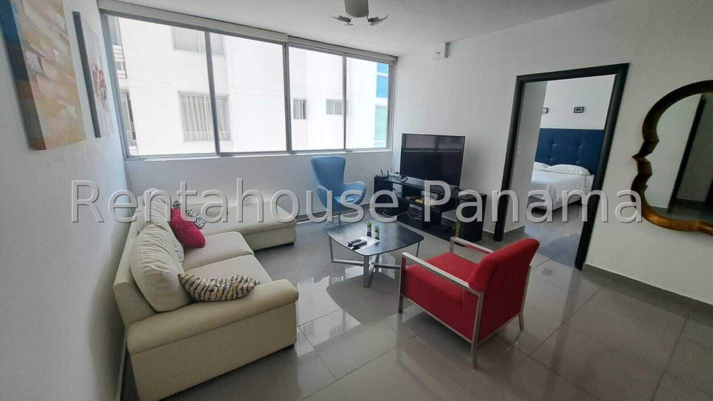 Spacious furnished living room with large windows and tile flooring in PH Quartier 74 Panama City