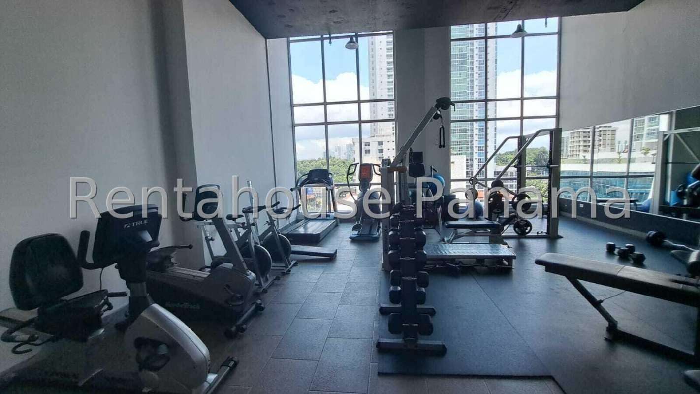 Modern residential gym with large windows and cityscape view in PH Quartier 74 Panama