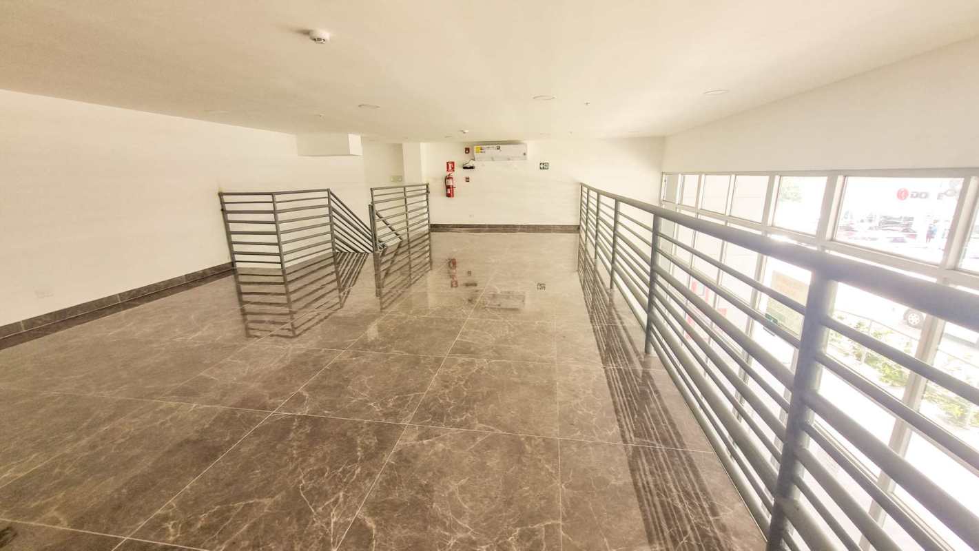 Open bright commercial interior lobby with marble tiles and large windows at Torre Comercial El Carmen Panama City