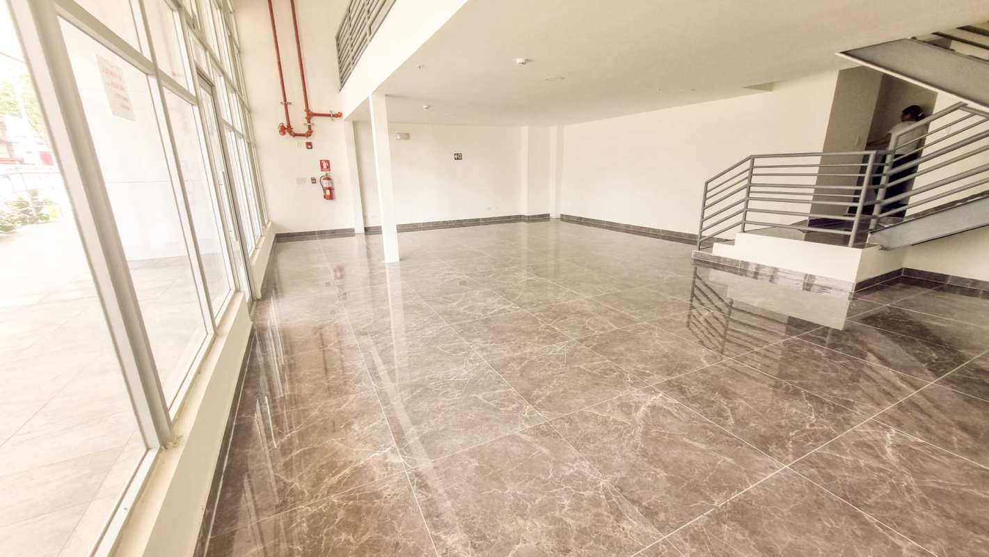 Accessible commercial bathroom with beige ceramic tiles and modern fixtures at Torre Comercial El Carmen Panama