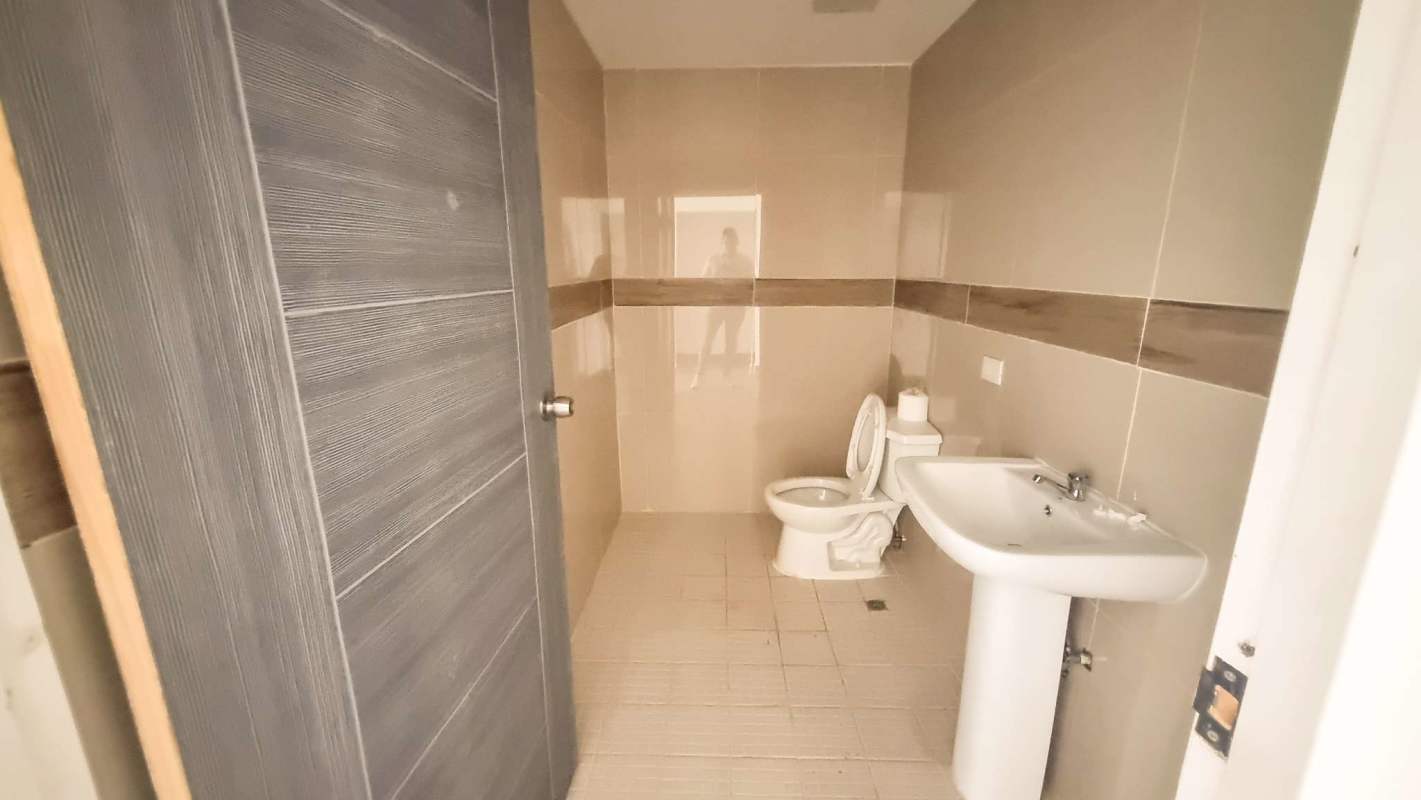 Covered commercial entrance with ramp, planters, and city street view at Torre Comercial El Carmen Panama