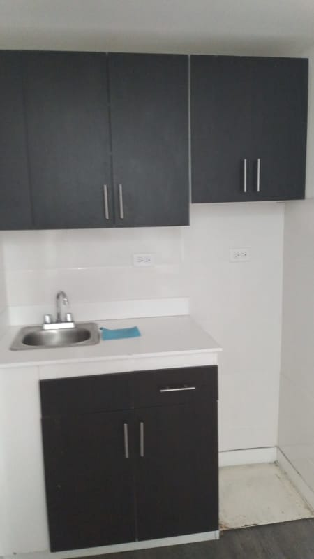 Industrial warehouse space interior with chain-link fence and metal roofing in Panama City