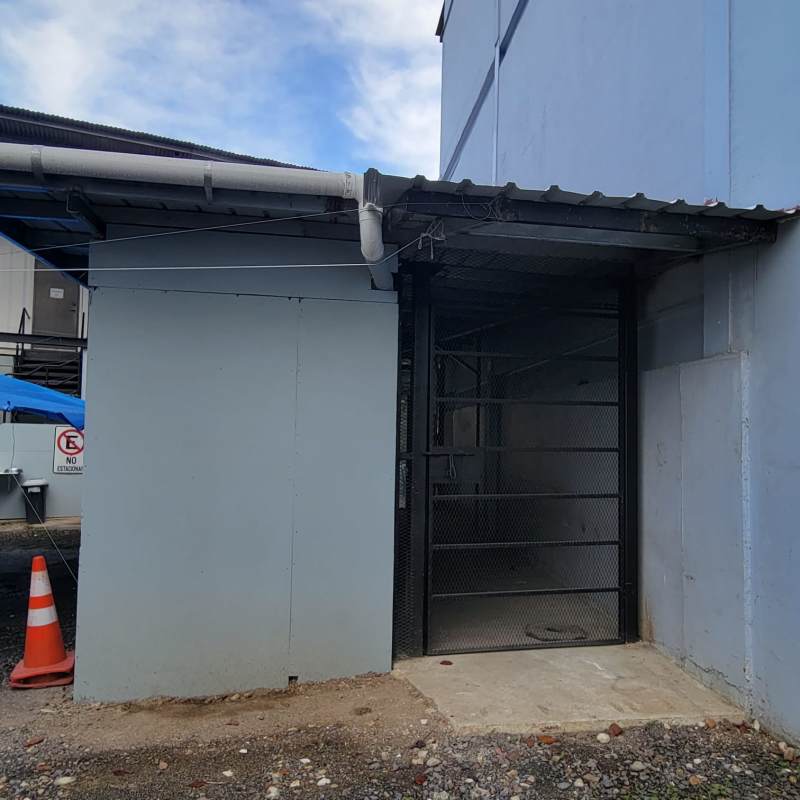 Blue painted modular container style warehouse building with metal gate in 12 de Octubre area
