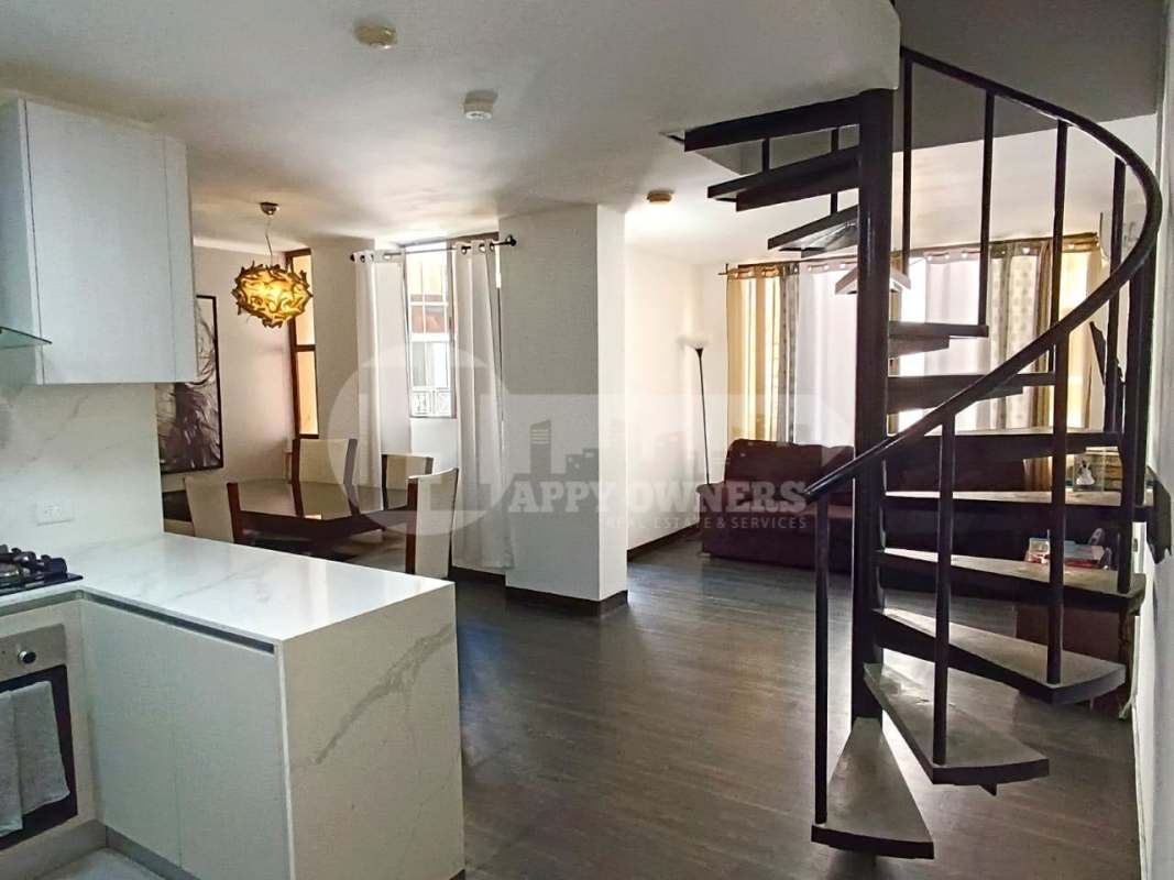 Living and dining room with spiral staircase modern interior PH Torres del Rey Panama City