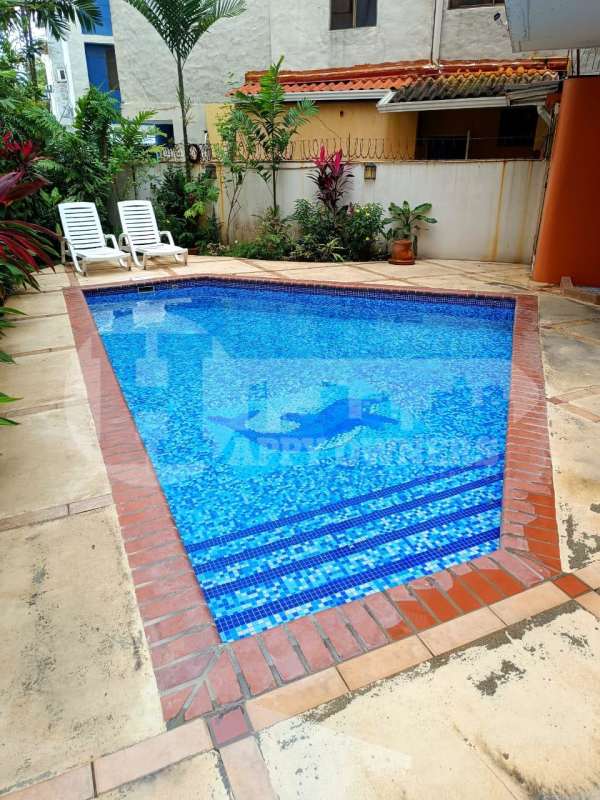 Outdoor swimming pool with deck and tropical plants at PH Torres del Rey Panama