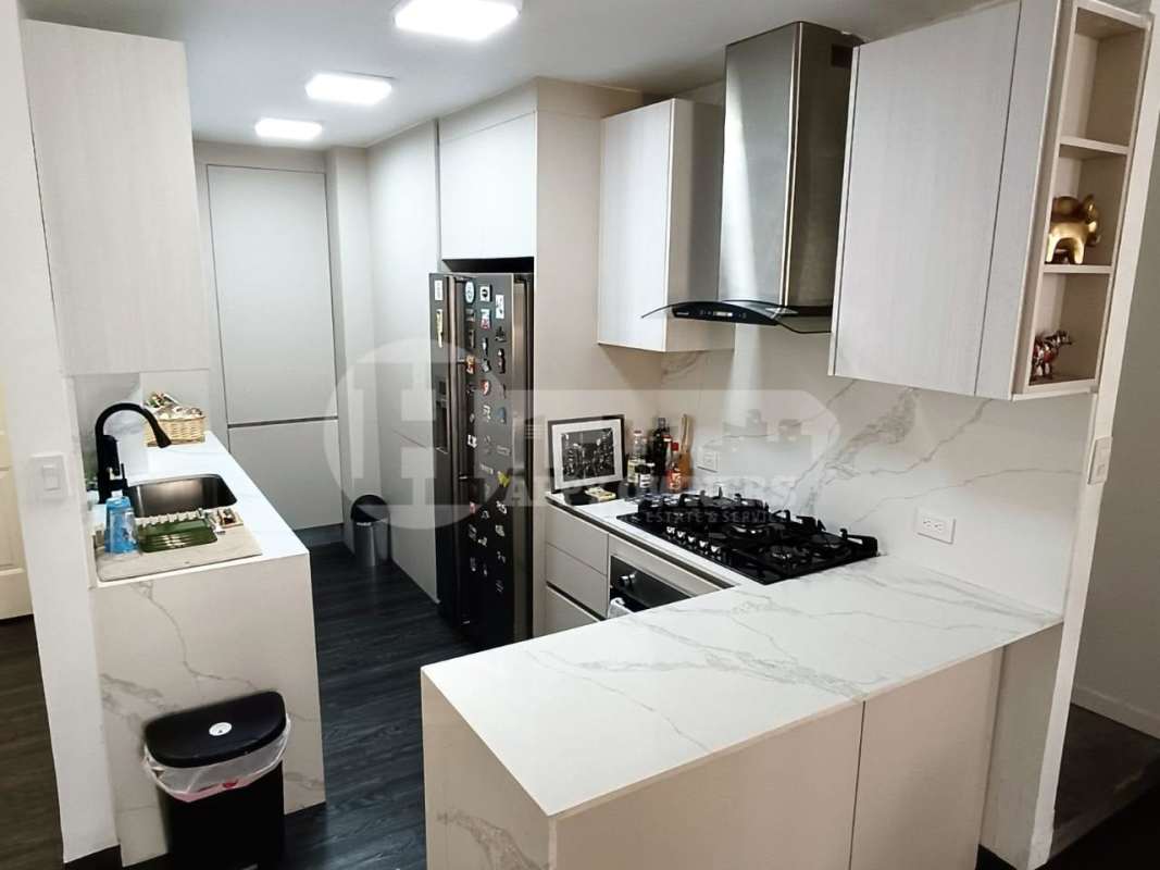 Kitchen area with marble counters, gas stove, cabinets PH Torres del Rey Panama City