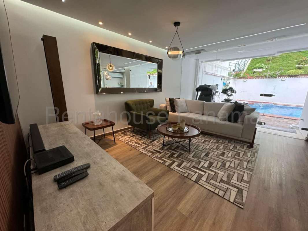 Bright open living room with modern finishes and garden view Green Valley Residence Panama