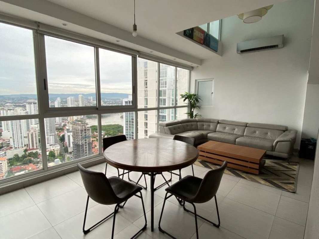 Large living and dining area with floor-to-ceiling windows overlooking Panama City in PH Coco del Mar