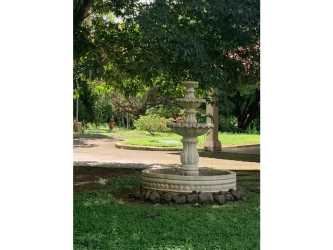 Traditional multi-tier fountain surrounded by green landscaped area in luxury countryside estate Chitré