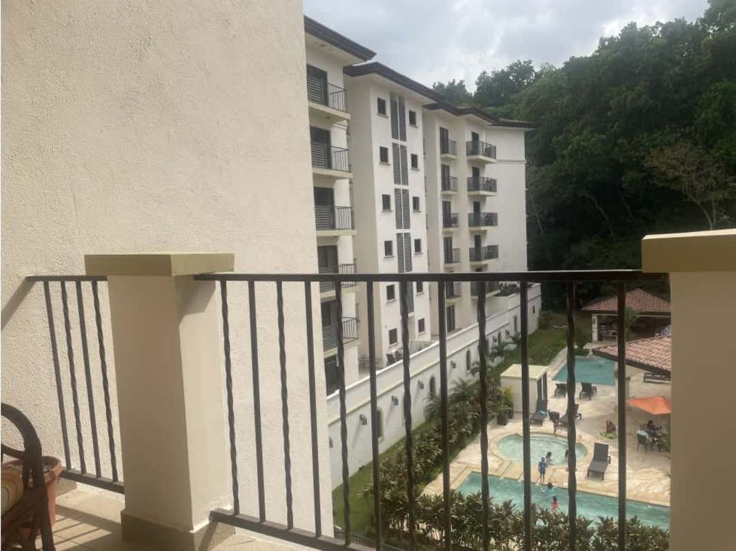 Resort-style condominium with lush gardens and blue swimming pool in Embassy Village Panama