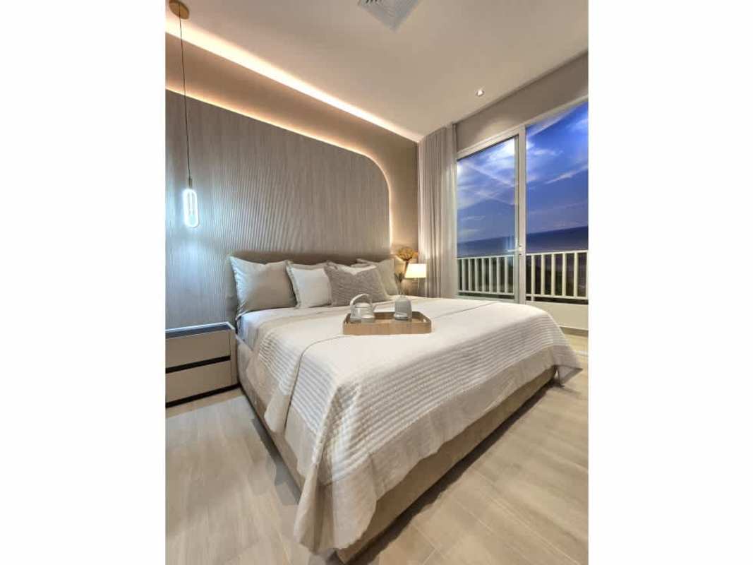 Modern bedroom with large window and balcony overlooking ocean skyline in PH Ipanema Costa del Este