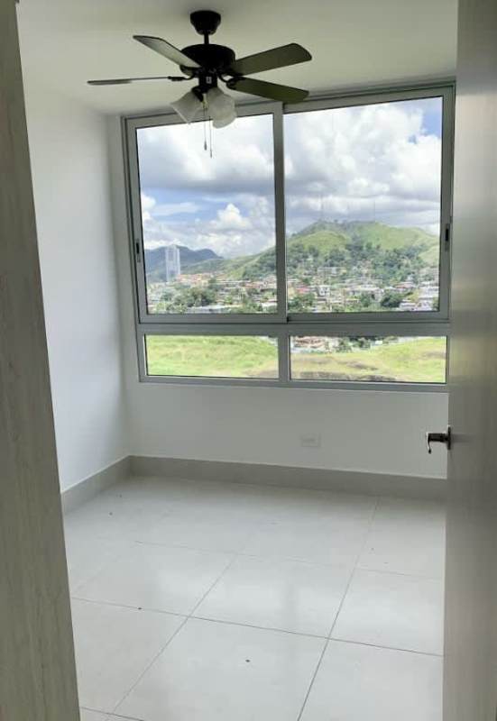 Bedroom with large windows and scenic views overlooking Panama City and green hills at PH Green Wood