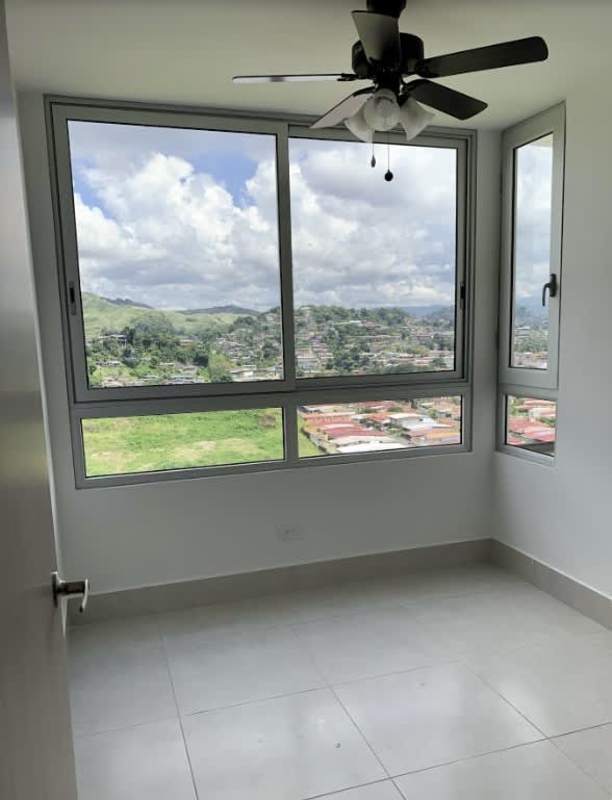 Bedroom with large corner windows overlooking city skyline and mountains PH Green Wood Panama