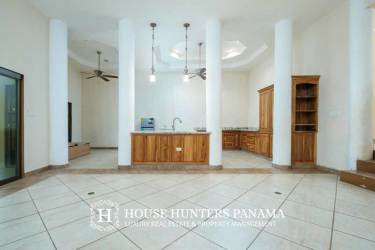 Spacious living area with ceramic floors, white columns, tray ceiling, open plan in Sortova Panama
