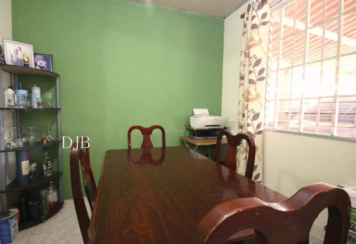 Bedroom with wooden bed, dresser, rocking chair, window with curtains in Pacora Panama