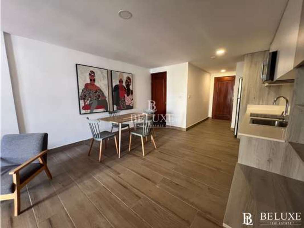 Open plan loft living room with balcony, exposed stone, modern finishes in Casco Viejo Panama