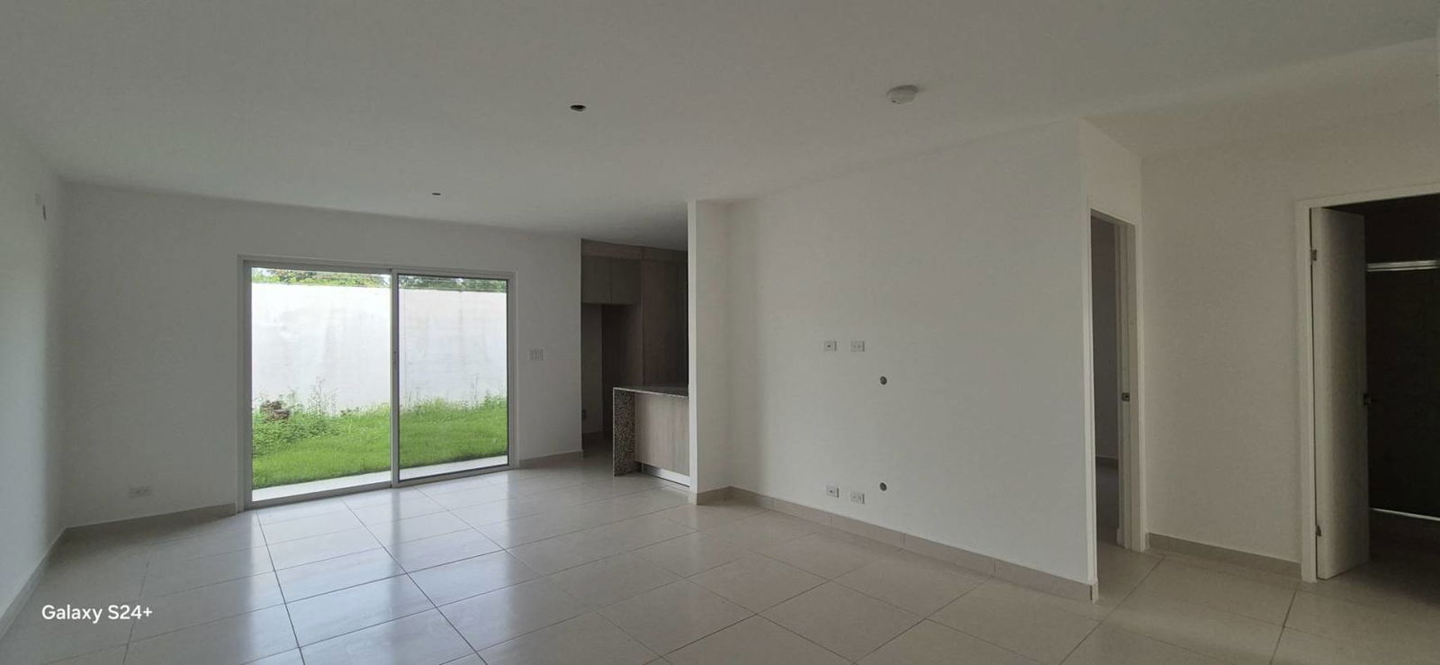 Spacious living and dining open area with sliding glass door to the backyard in Villa Sur Costa Sur Panama