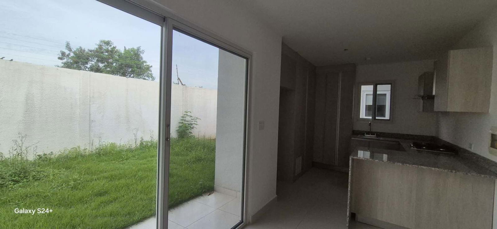 New kitchen with granite countertop, sliding glass door to backyard, bright space in Villa Sur Costa Sur Panama