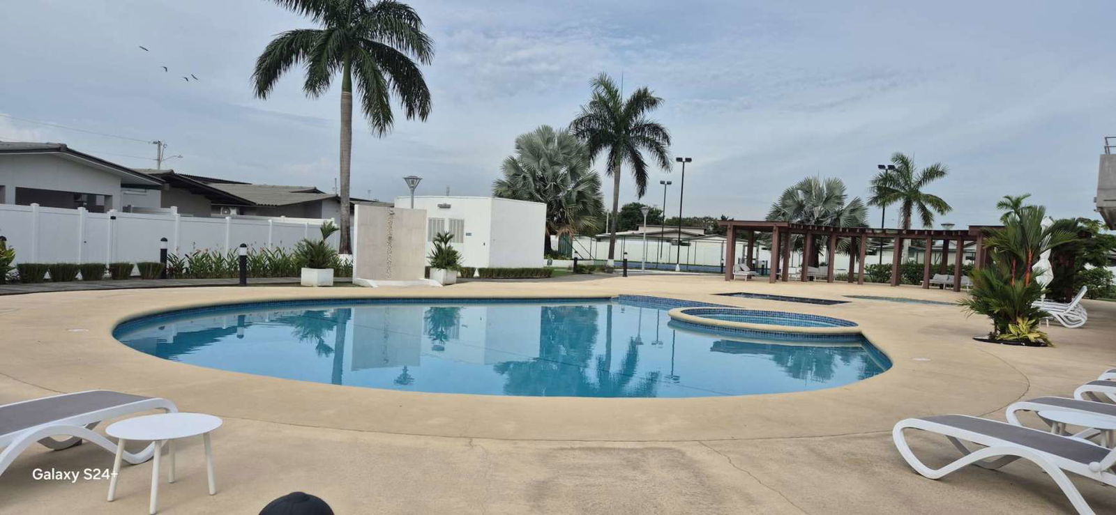 Large outdoor swimming pool with jacuzzi, tropical landscaping, and lounge areas in Villa Sur Costa Sur Panama