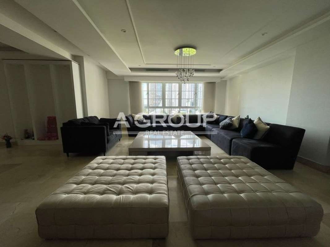 Luxury apartment living area with large sectional, chandeliers, bright windows in PH Balboa Tower Panama