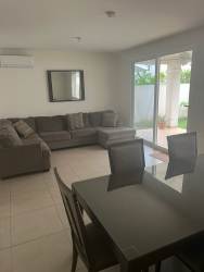 Contemporary kitchen with stainless steel appliances, wood cabinetry, and white countertops in Panama Pacifico rental house