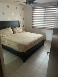 Spacious living room in furnished rental home at Bosques del Pacífico Panama Pacifico with large sliding glass doors and porcelain floors