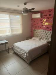Furnished master bedroom with neutral decor, AC unit, ceiling fan and ensuite at Bosques del Pacífico in Panama Pacifico