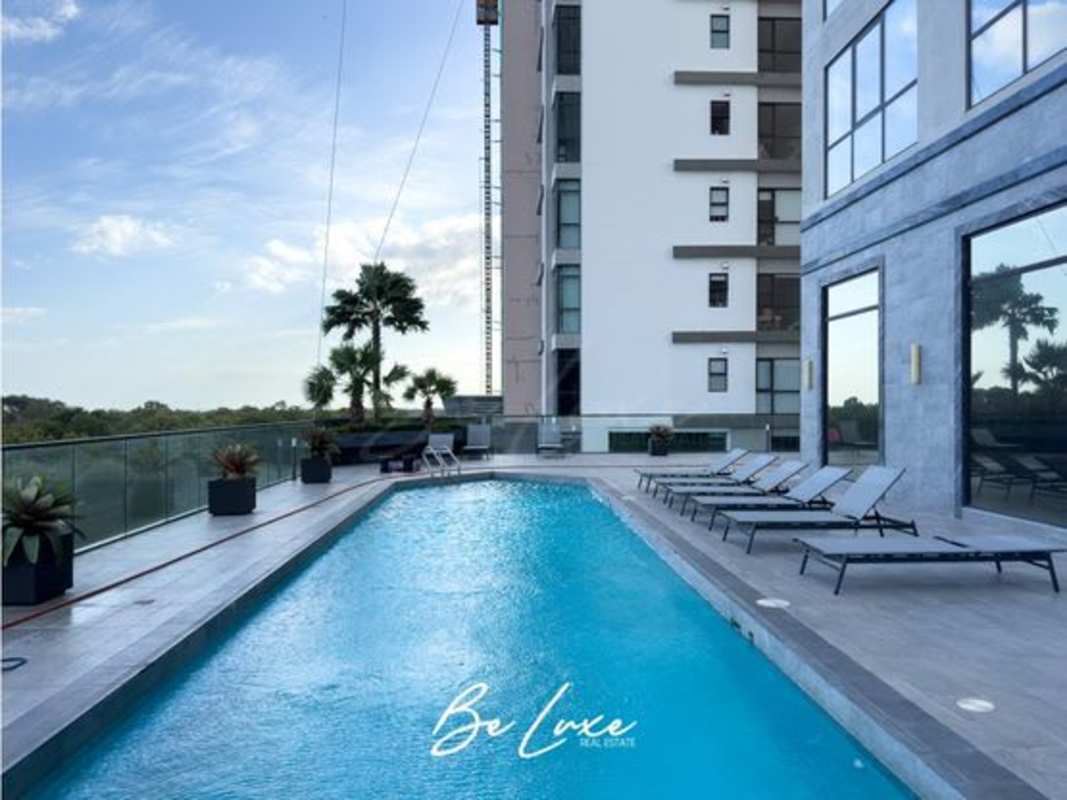 Luxury infinity pool with sun loungers overlooking golf course at Empire Residences Panama