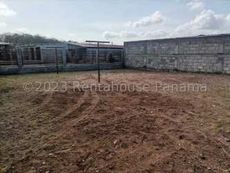 Enclosed dirt yard with cement block wall and clotheslines in Penonomé