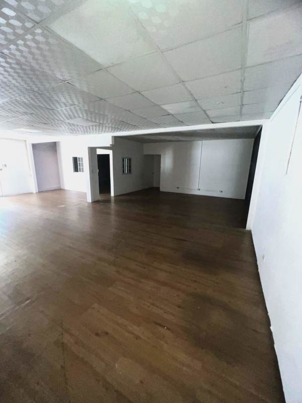 Empty office with wood flooring drop ceiling and partition wall with window panels Bethania Panama