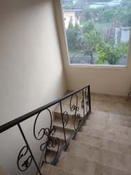 Two-story multi family beige facade stone accent balconies palm in yard Las Tablas