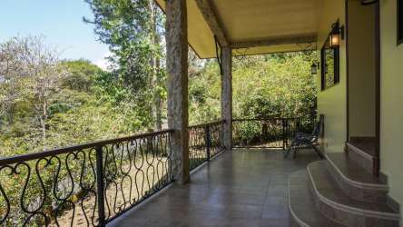 Covered tiled terrace overlooks lush garden mountain landscape Altos del María