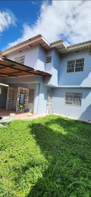 Light blue painted two-story house with covered patio and green yard in PH Colinas del Golf Brisas del Golf Panama