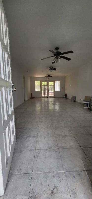 Open plan living dining with tile floors and double doors to garden in PH Colinas del Golf Brisas del Golf Panama