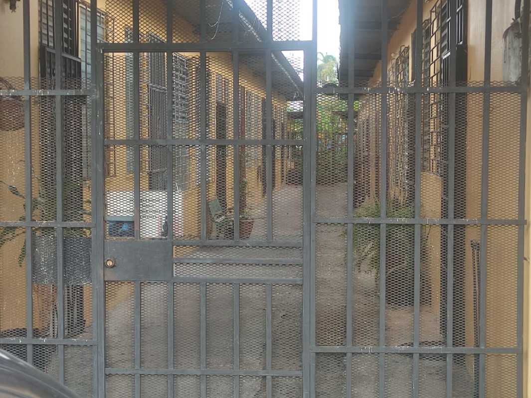 Gated corridor with apartment entrances and barred windows in 16-unit building Parque Lefevre Panama