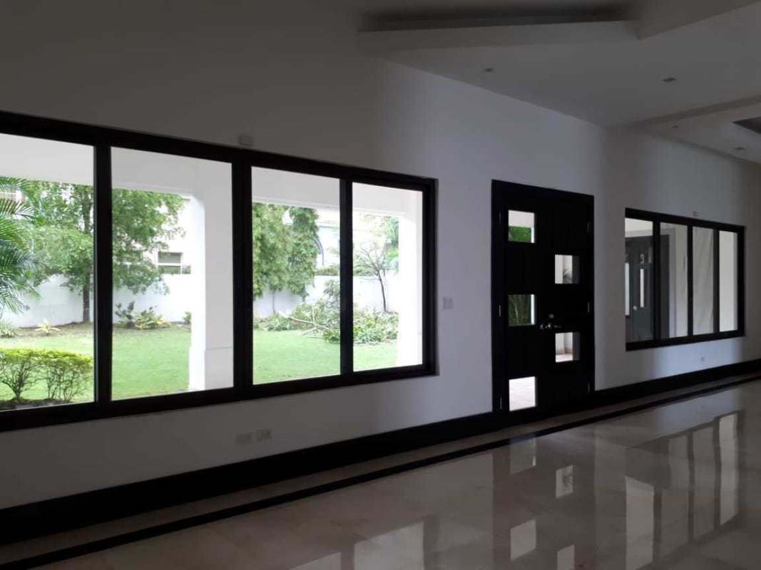 Spacious walk-in closet with built-in dark wood shelves in Costa del Este luxury home Panama