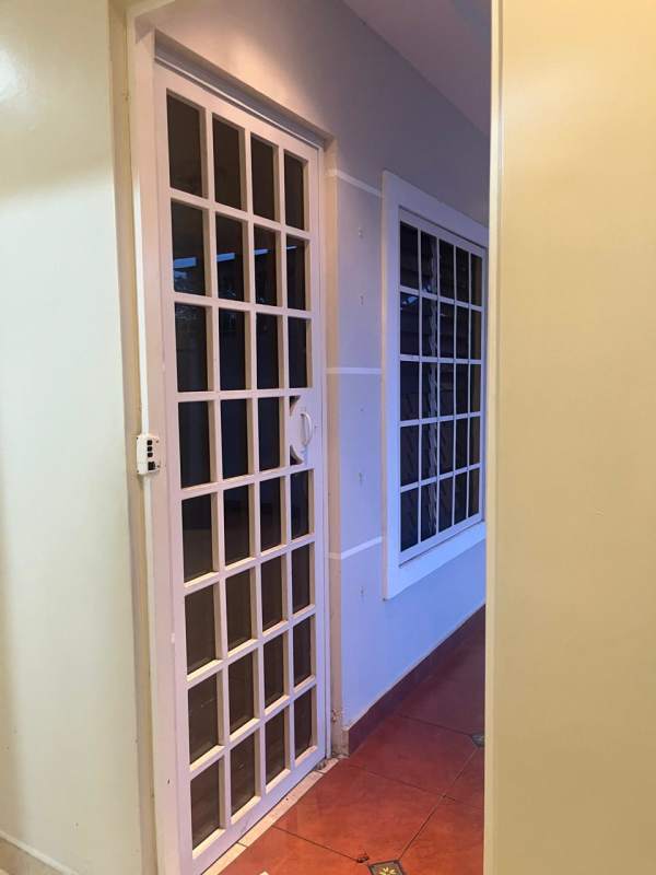 Hallway with sliding glass grid doors leading outside duplex house San Antonio Panama