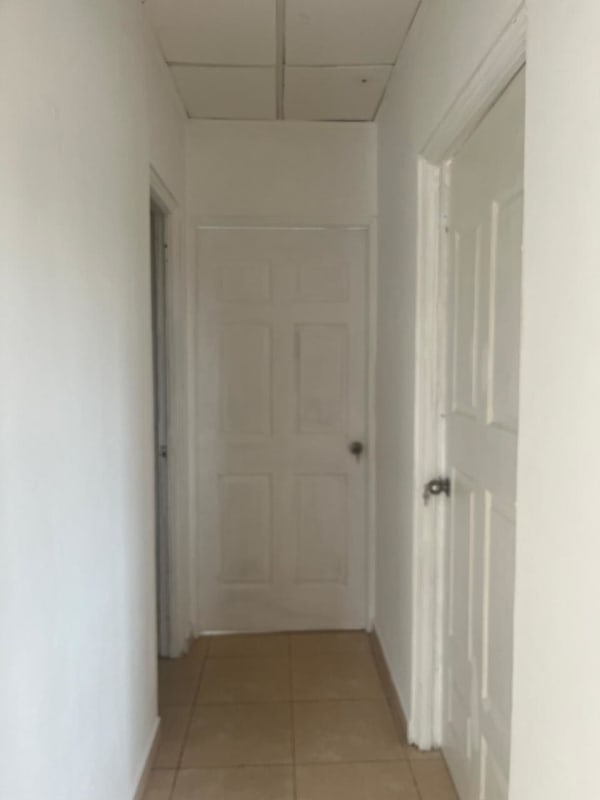 Bedroom with built-in white closet and tiled floor in Panama house Cerro Viento