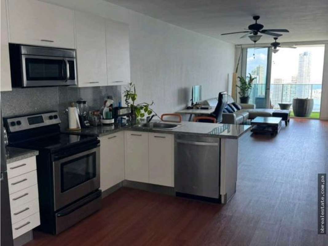 Living room with hardwood floor opening to ocean view balcony in PH White Tower Panama