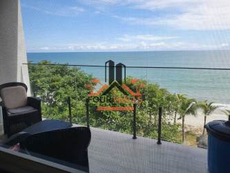 Modern kitchen with granite island, white cabinetry and appliances in beachfront condo Playa Caracol Panama