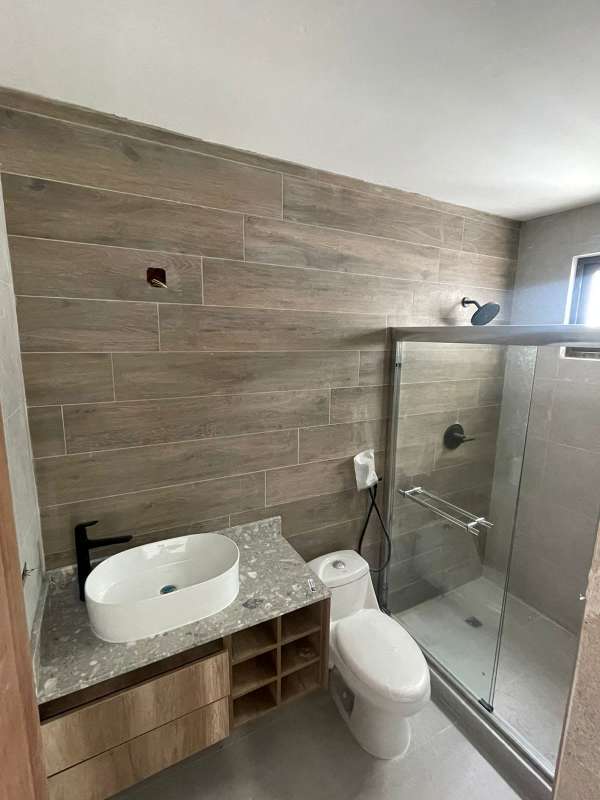 Bathroom with wood-look tiles, vessel sink, matte black fixtures in PH Brisa Marina Costa del Este Panama