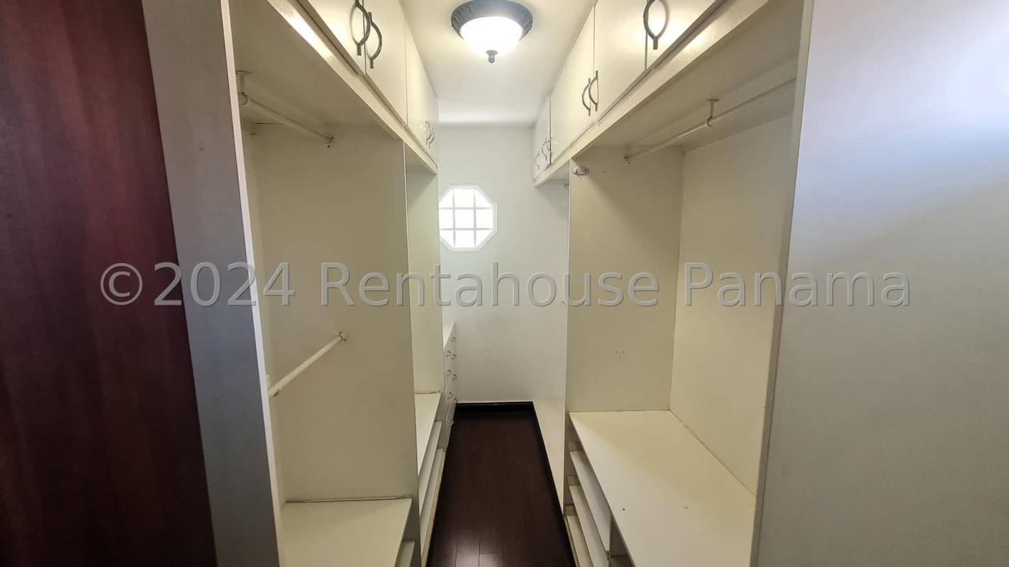 Spacious living room with tile flooring, wooden cabinets, chandeliers, iron stairs Costa del Este Panama