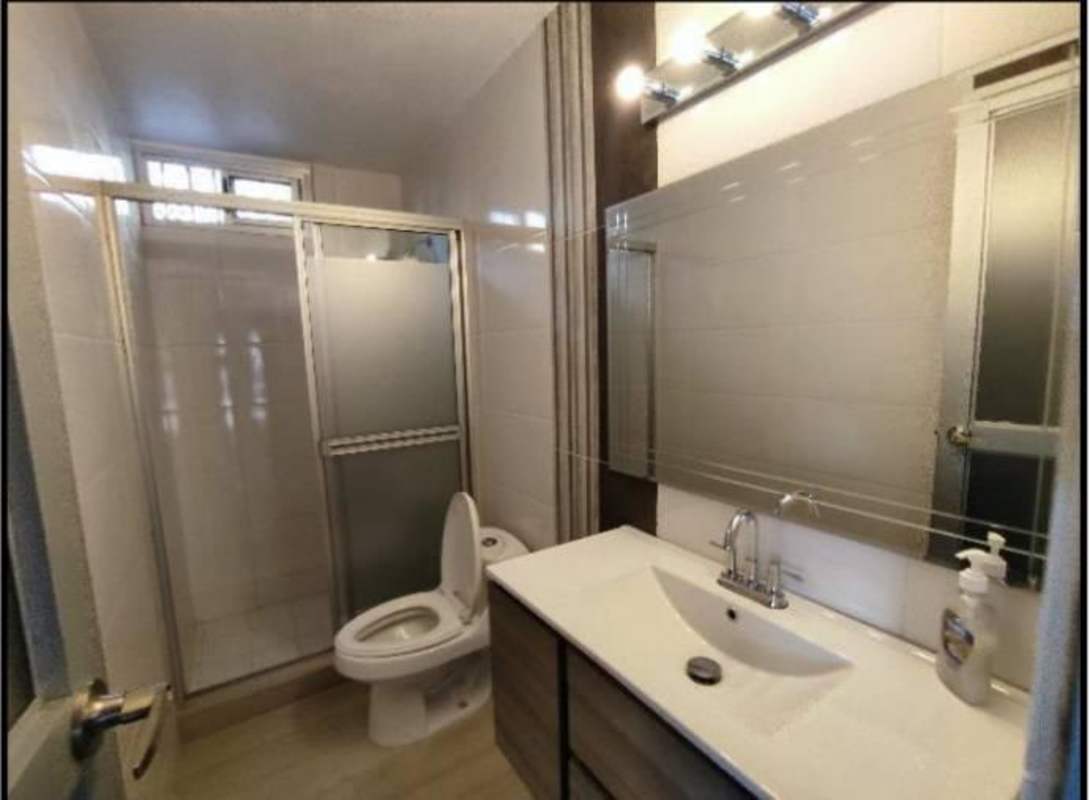 Modern bathroom with frosted glass shower, vanity, mirror at commercial property Panama
