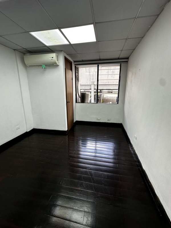Empty medical office room with hardwood floor, AC, window bars in PH San Fernando Panama