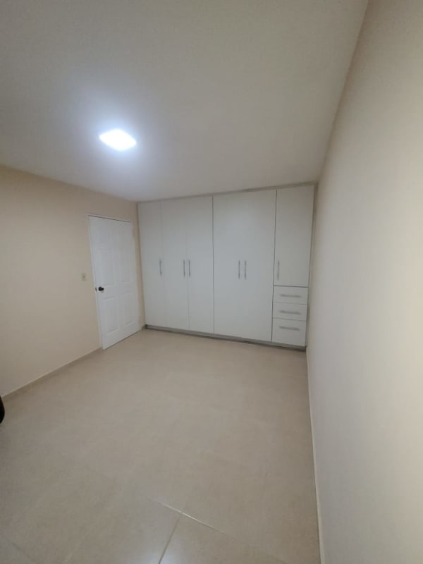 Minimalist bedroom with built-in wardrobe, neutral tiles and walls in PH Morada del Sol 12 de Octubre